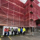 Photo of contractors, partners and colleagues in front of the scaffolding at Woodcote House