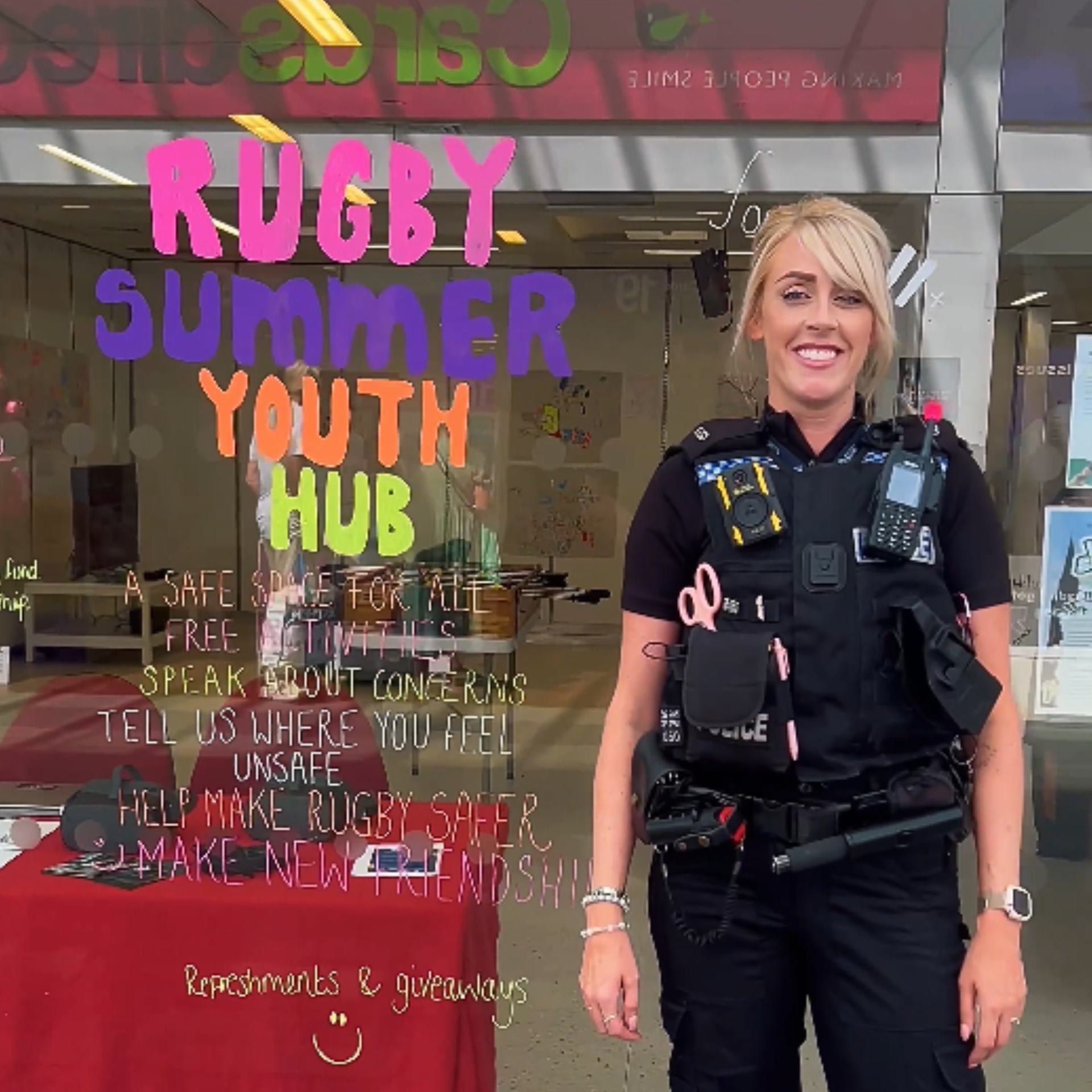 Image of the Rugby youth summer hub with a police officer standing next to it